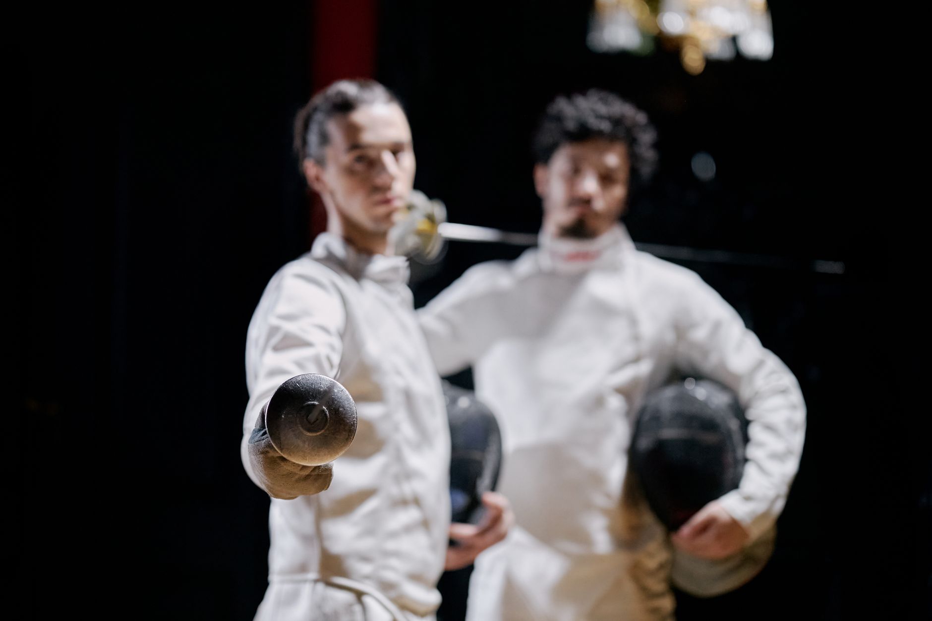Fencer in white breeches and jacket demonstrating the fitted athletic silhouette