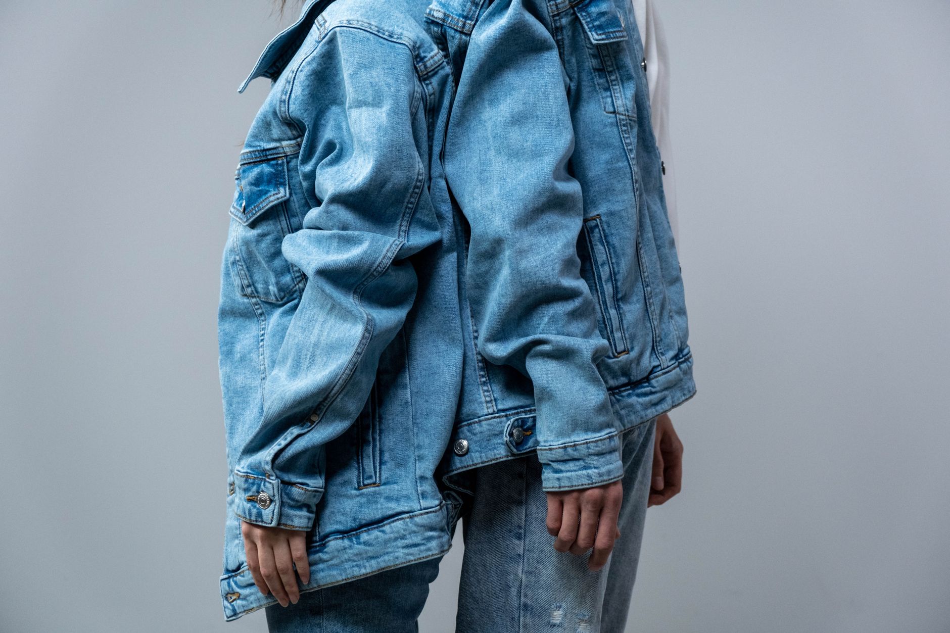 Person wearing a graphic jersey layered under outerwear in an urban setting