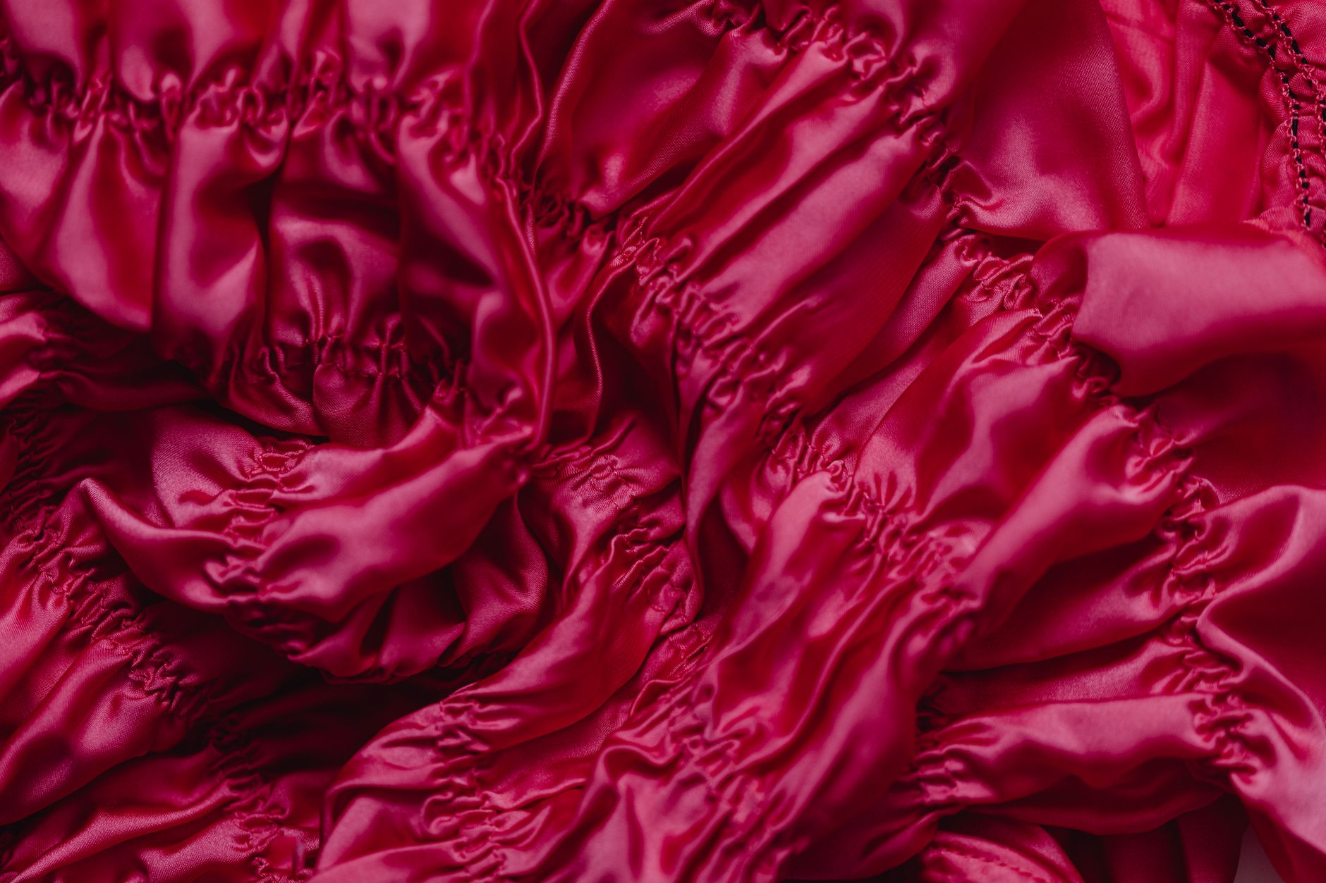 Close-up of a structured satin evening dress bodice showing minimal back strap construction