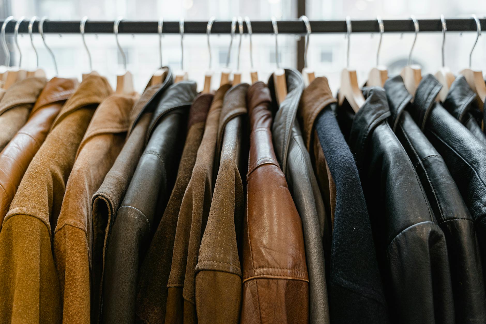 Interior of a luxury fashion retail space displaying structured coats on minimalist racks