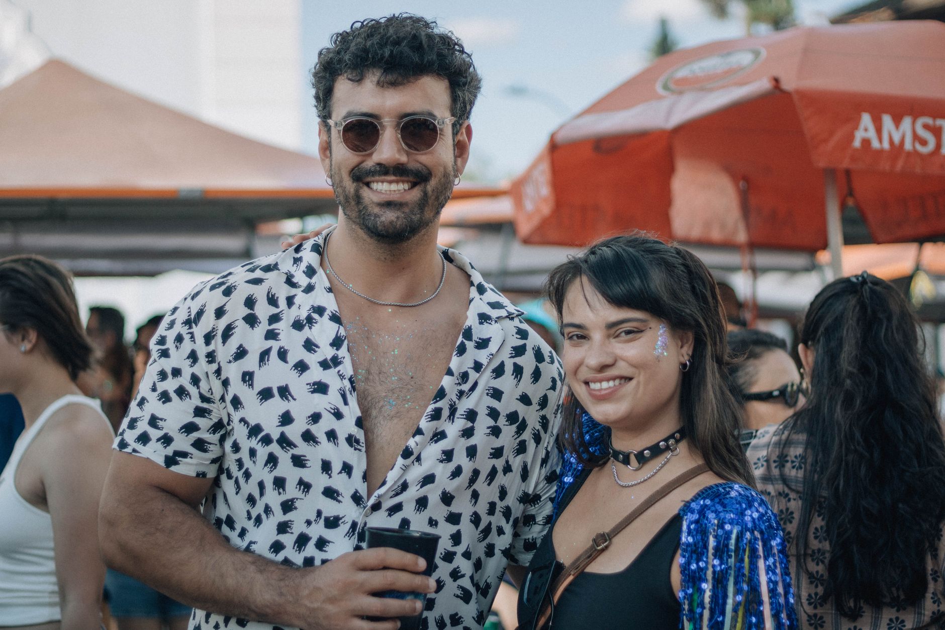 People in athletic-inspired layered outfits at an outdoor summer festival
