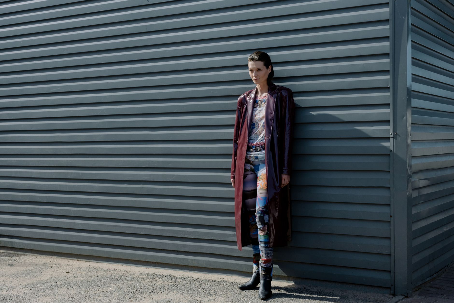 Model wearing a structured coat with close-fitting neckline and padded torso in a fashion editorial setting
