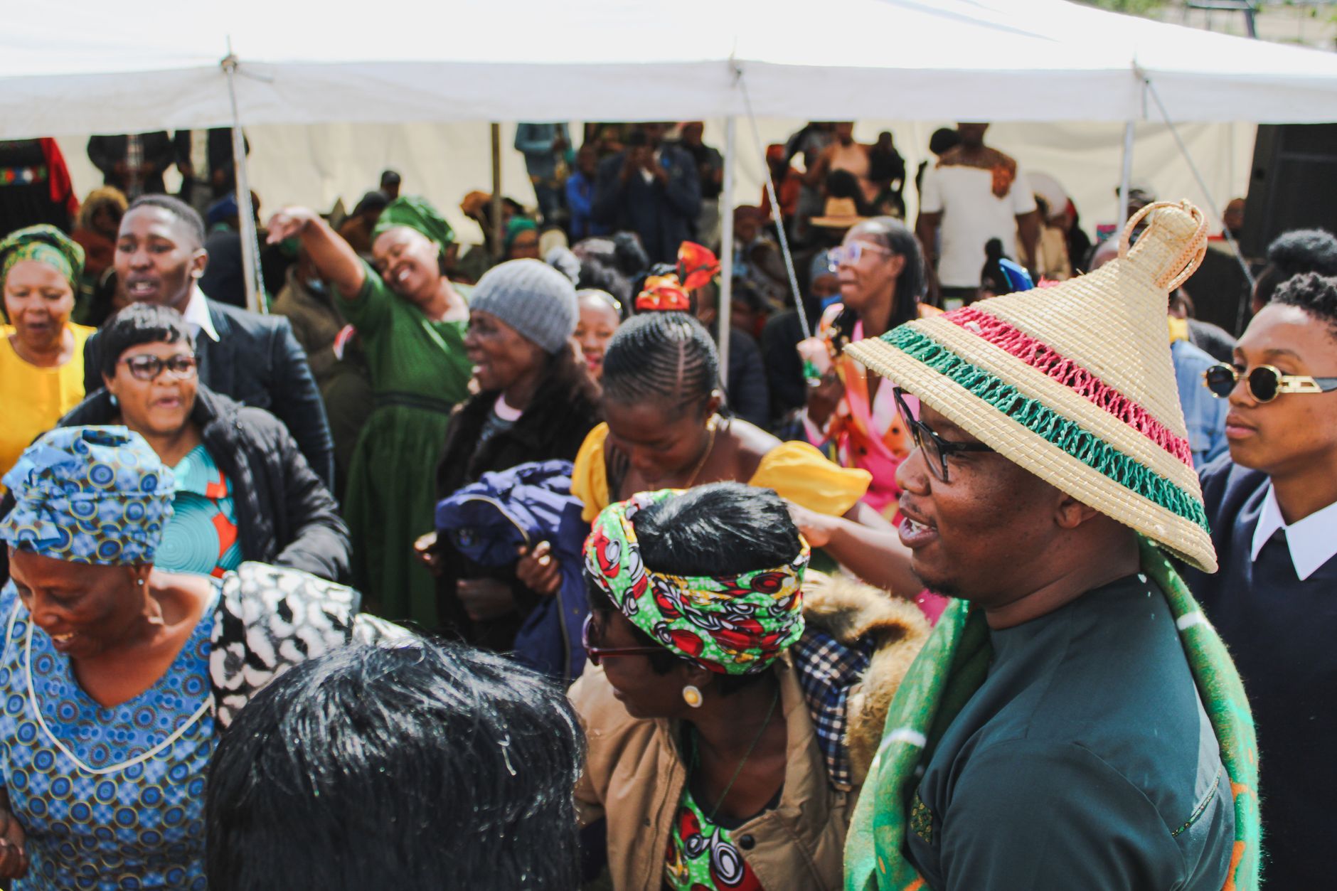 Festival attendees in layered summer outfits gathered at an outdoor music event