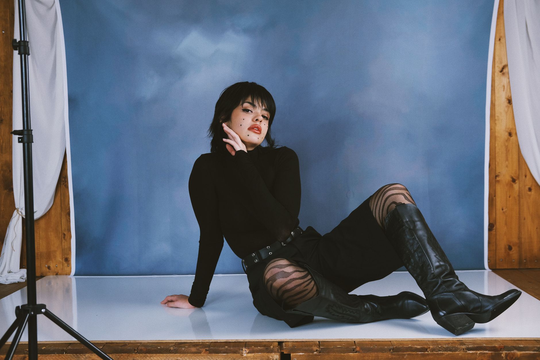 Studio portrait of a person in a high-neck structured knit garment with clean monochromatic styling
