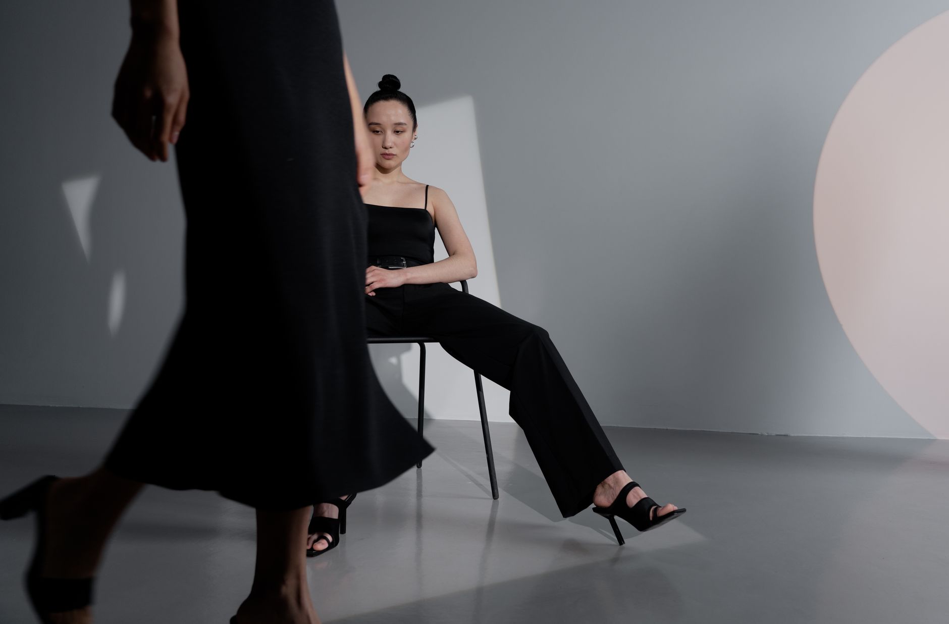 Model wearing a structured knit tabard with wide-leg trousers in a minimal setting