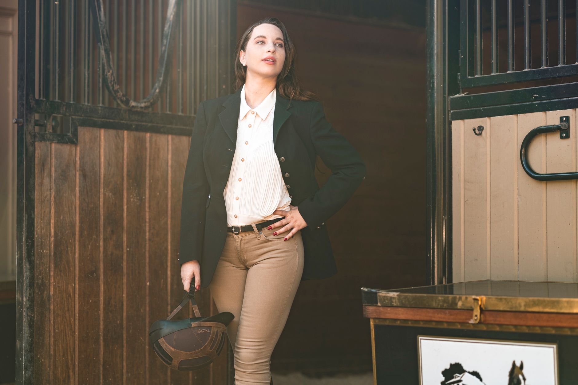 Structured leather equestrian protective accessories arranged on a neutral surface in an editorial still-life setting
