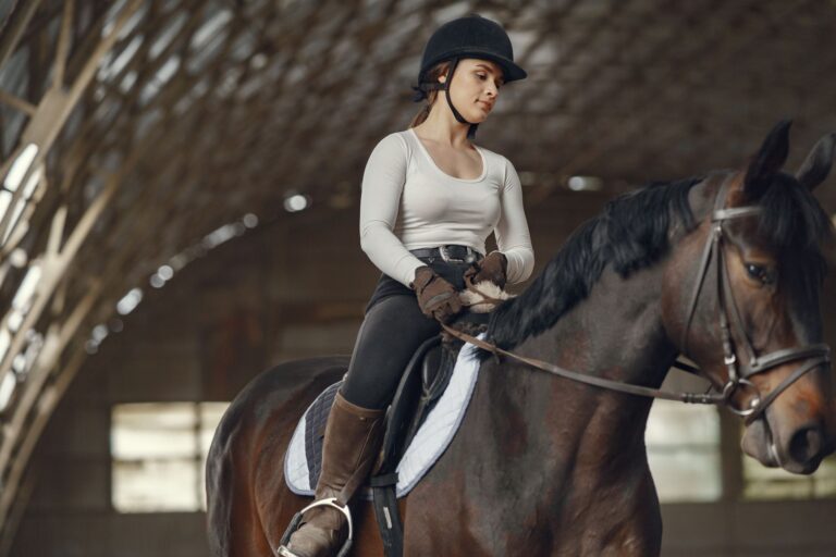 Close-up of structured riding trousers with reinforced knee paneling in neutral fabric