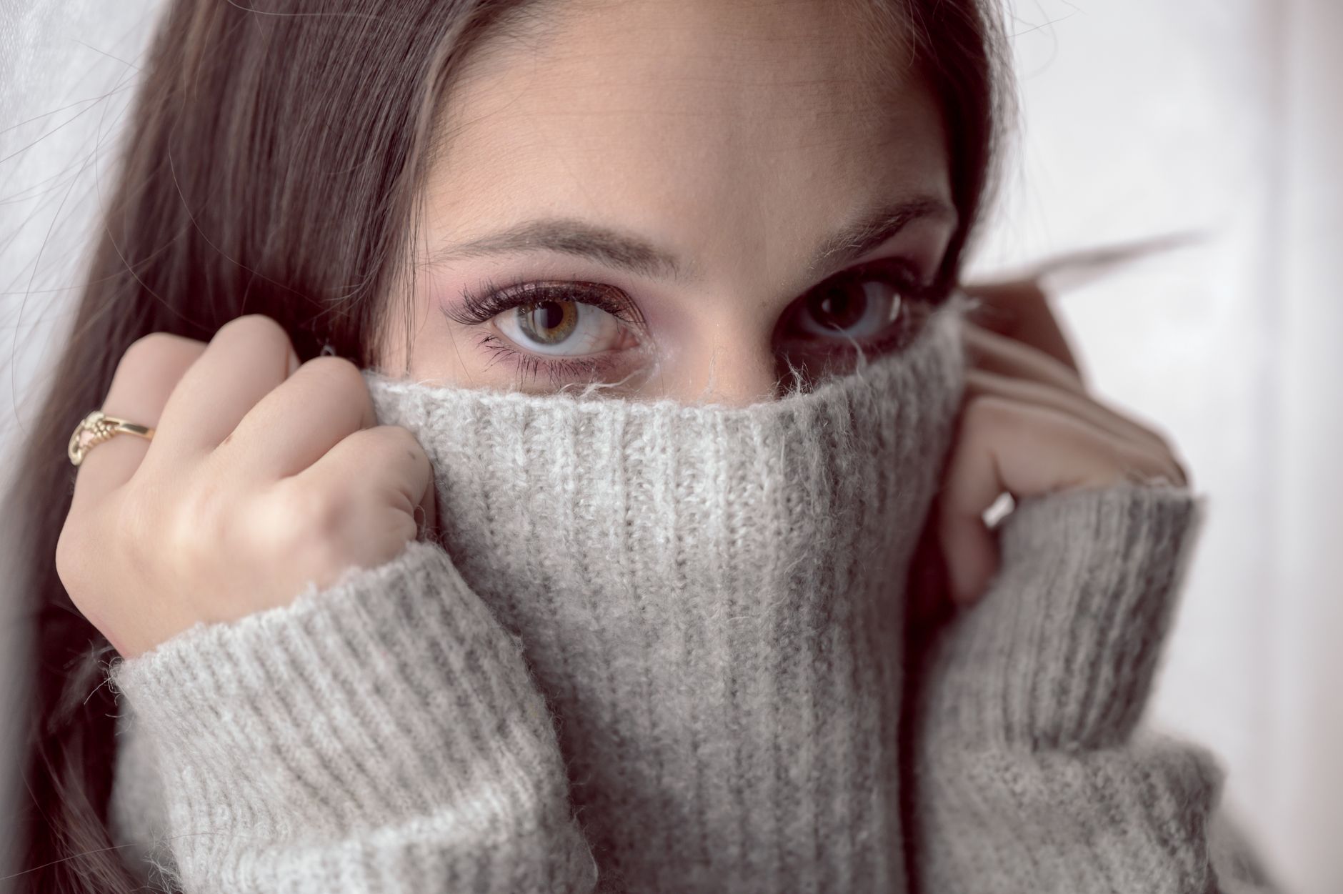 Close-up of a structured turtleneck knit garment in neutral tone showing textured stitchwork