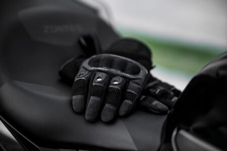 Polo Club Riding Gloves Are Quietly Gripping Minimalist Outerwear Drops Close-up of tan cabretta leather polo riding gloves with snap closure detail