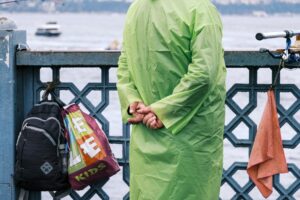Polo Water Sports Dry Bags Are Quietly Docking Into Luxury Tote Design A roll-top dry bag in matte coated nylon resting on a wooden dock surface