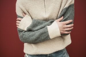 Rowing Club Blade Colours Are Bleeding Into Resort Stripe Knitwear Colorful striped knit pullover folded on a light surface, showing bold horizontal stripe patterns in navy, cream, and gold