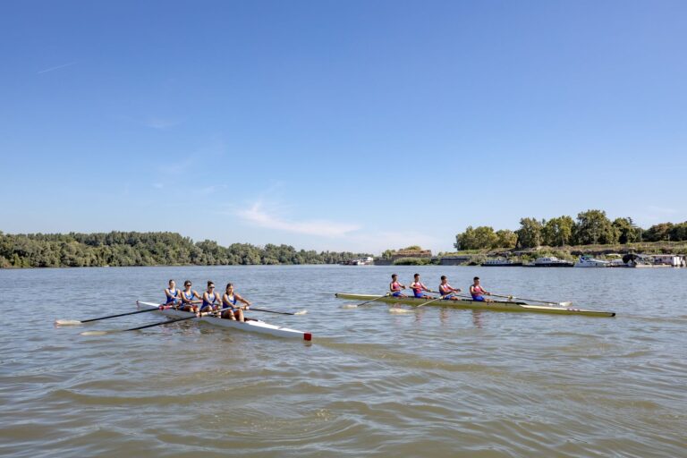Rowing team on a river in fitted athletic leggings during training