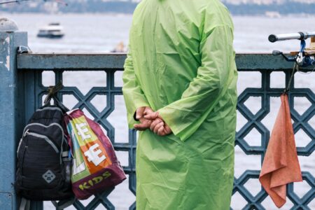 A roll-top dry bag in matte coated nylon resting on a wooden dock surface