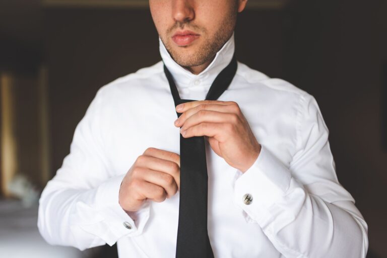 A crisp white formal dress shirt with a structured high collar laid flat on a clean surface