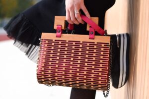 A structured leather handbag with a rigid oval opening frame on a neutral background