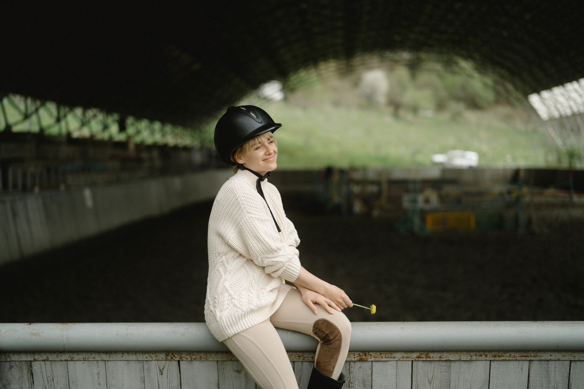 Model wearing structured outerwear and tall boots in an equestrian-inspired look