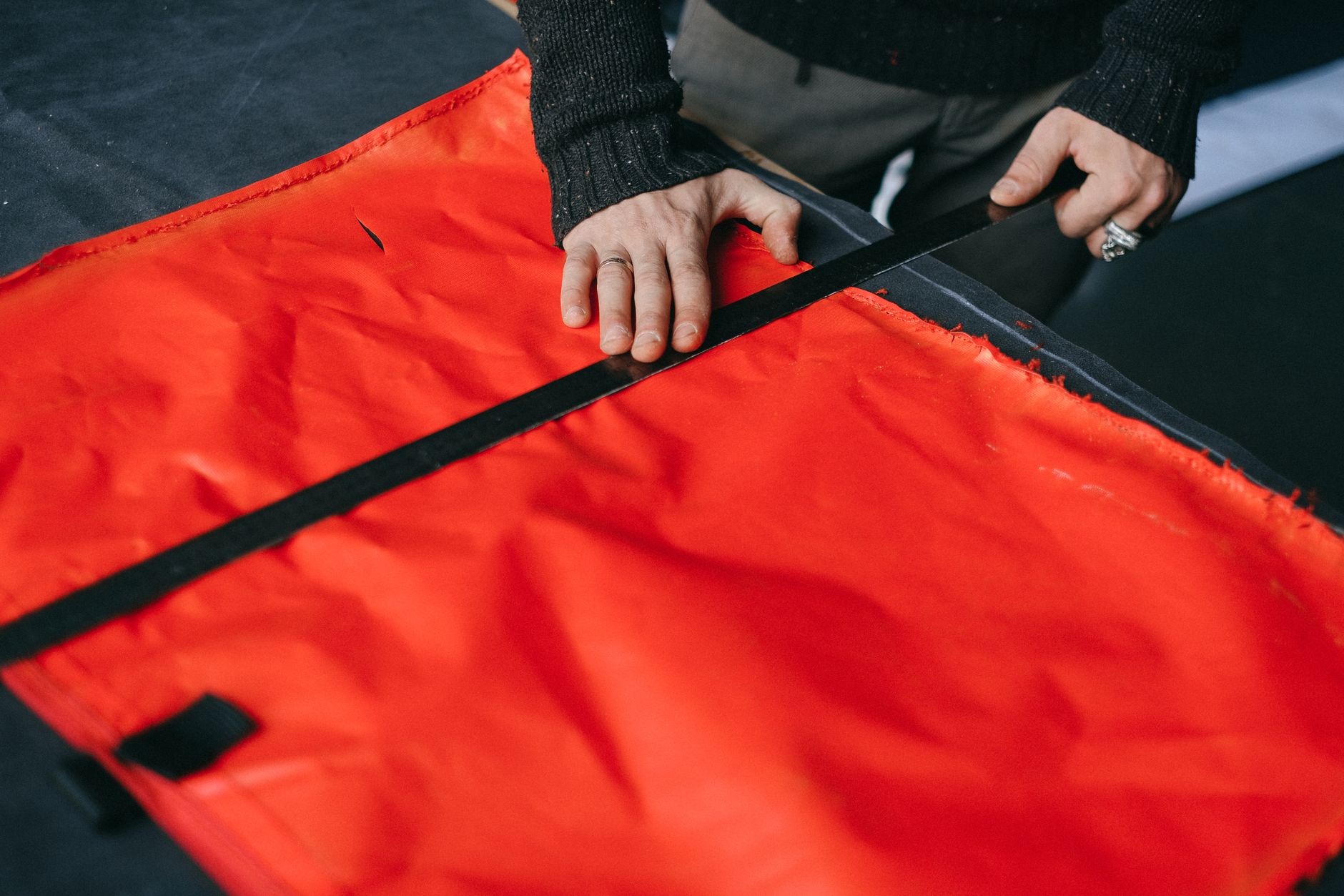 Designer working on a structured bag construction in an accessories studio