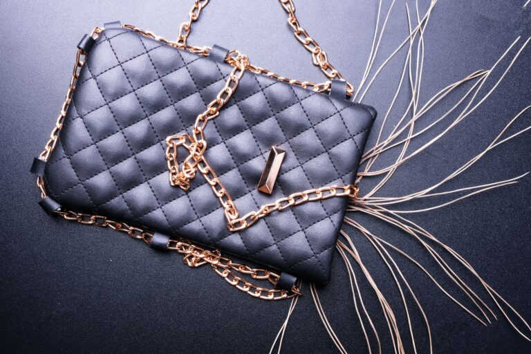 A structured leather clutch with a firm padded flap closure on a neutral surface