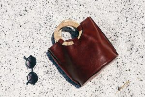 Fencing Épée Pistol Grips Are Quietly Moulding Into Sculptural Bag Handles Close-up of a sculptural leather bag handle with ergonomic contours on a structured tote