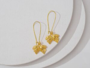 Rowing Club Zephyr Blades Are Quietly Edging Into Sculptural Earring Drops Close-up of elongated gold drop earrings with sculptural abstract form against neutral background