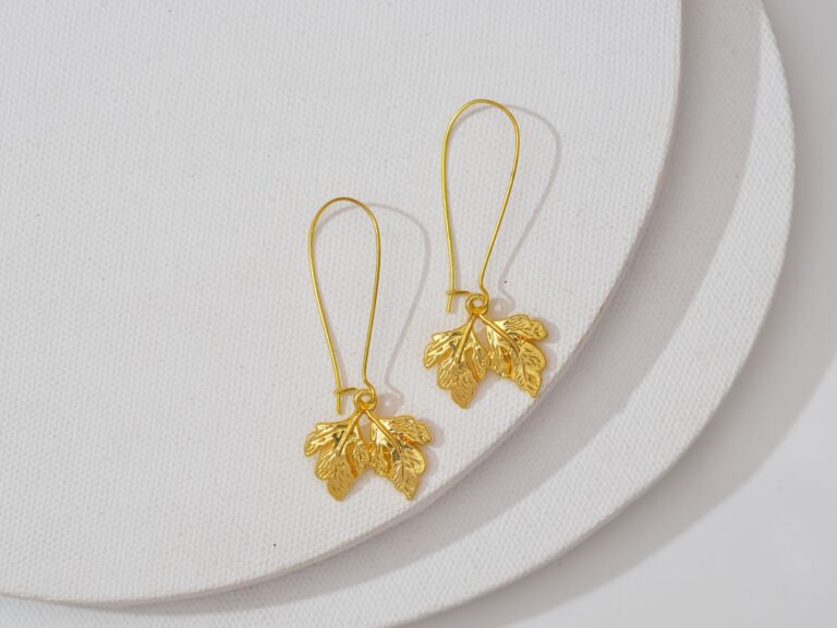 Rowing Club Zephyr Blades Are Quietly Edging Into Sculptural Earring Drops Close-up of elongated gold drop earrings with sculptural abstract form against neutral background