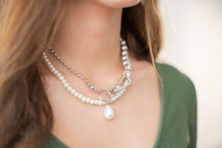 Close-up of a structured sculptural choker sitting low on a model's neck against a minimal background