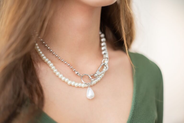 Close-up of a structured sculptural choker sitting low on a model's neck against a minimal background