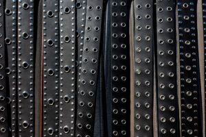 Polo Club Tail Guard Buckles Are Quietly Pressing Into Structured Belt Hardware Close-up of a structured leather belt with antique metal buckle hardware