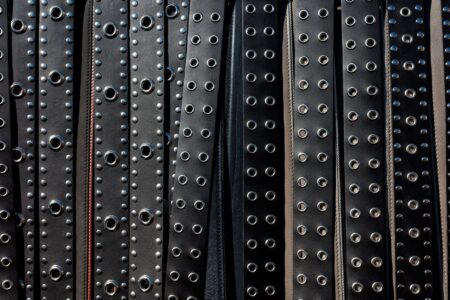 Close-up of a structured leather belt with antique metal buckle hardware