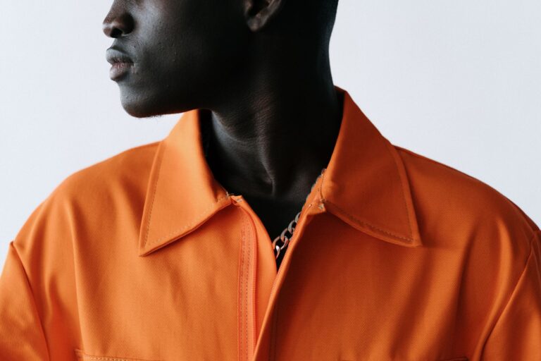 Close-up of a tailored jacket hem showing a contrasting fabric welt strip along the lower edge