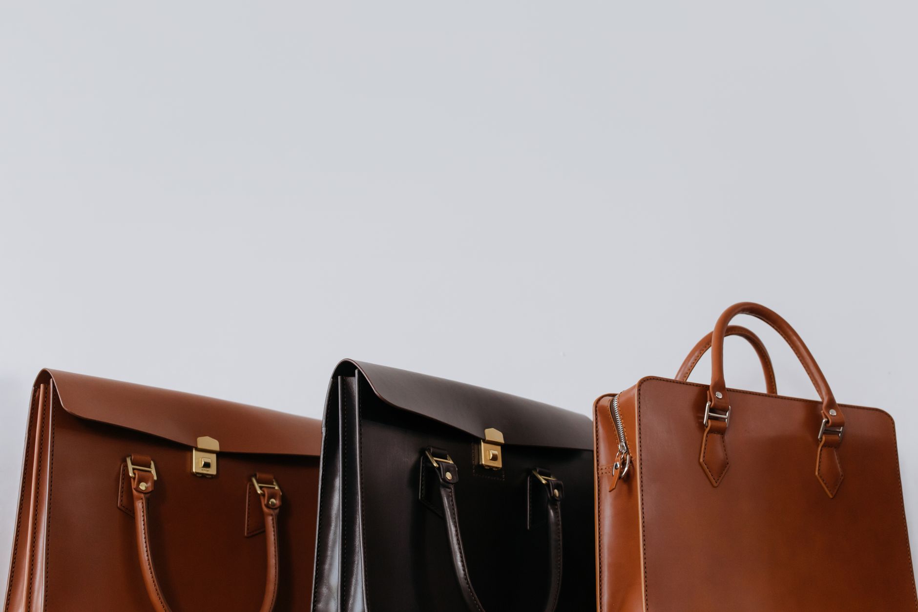 Structured canvas and leather bag with utilitarian hardware details and strap loops