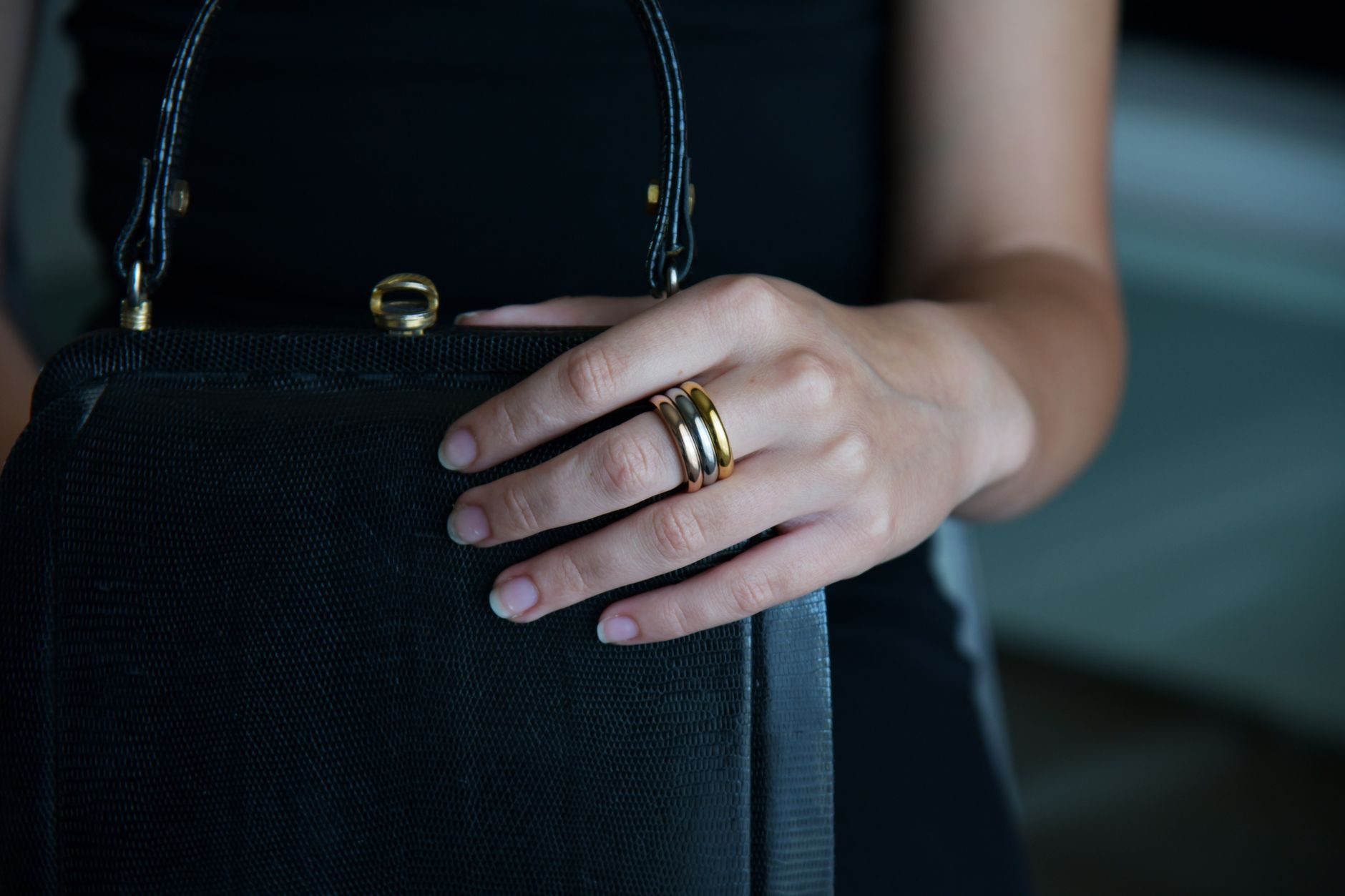 Minimalist wide band gold rings with structured closures arranged on a neutral surface