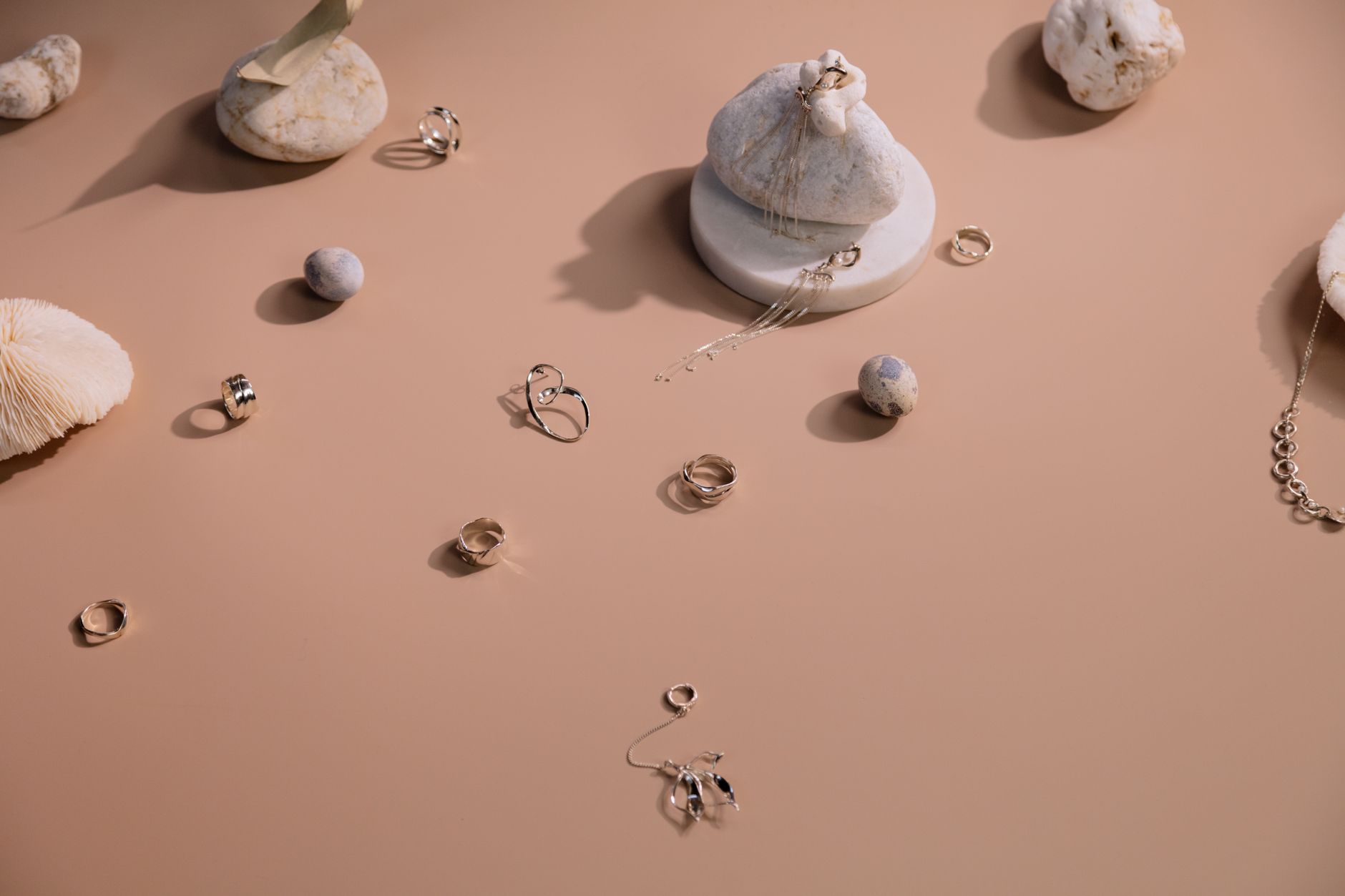 Sculptural silver jewellery piece framing the lower jaw and chin area