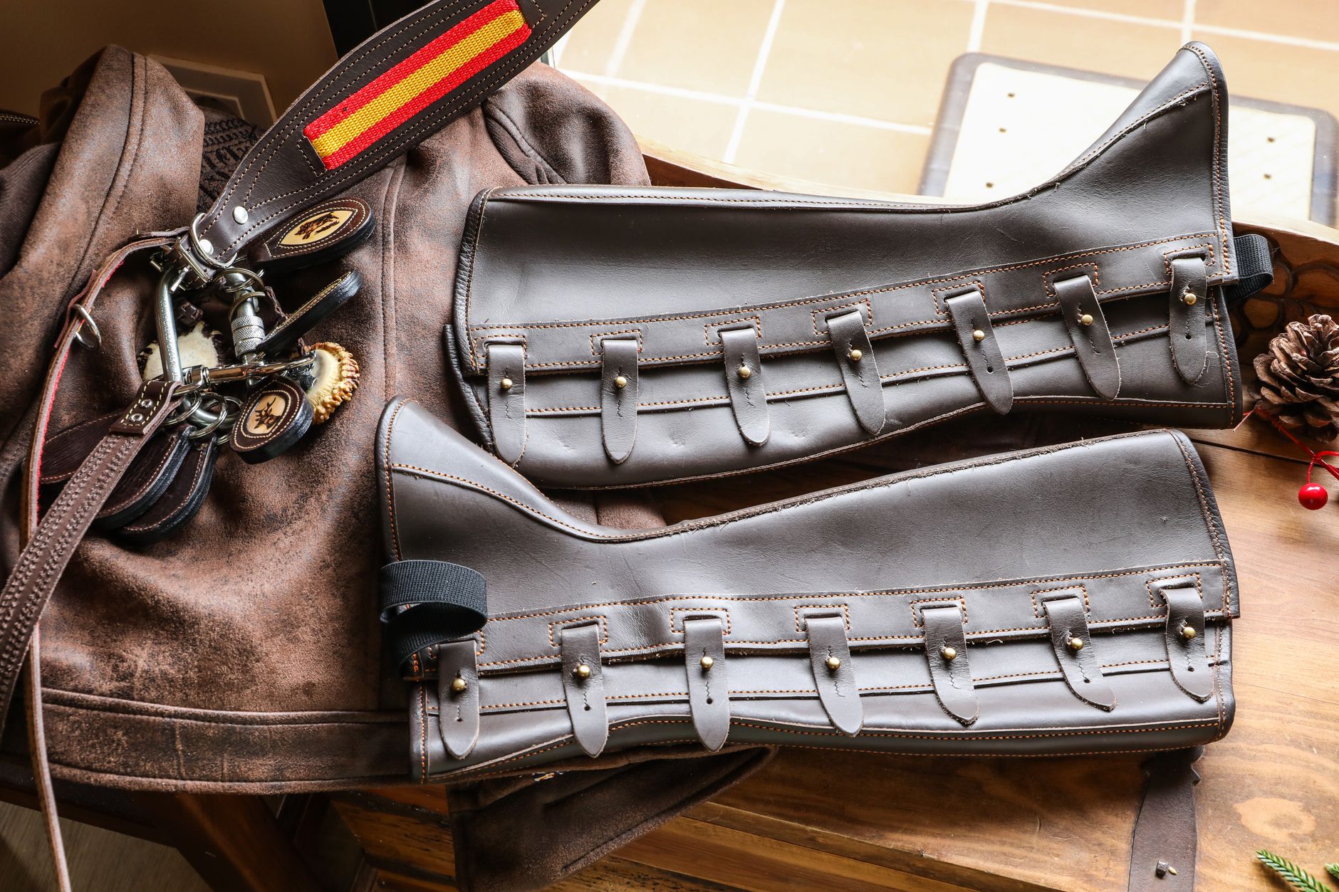 Detail shot of equestrian riding boots showing leather strap and buckle construction at the ankle