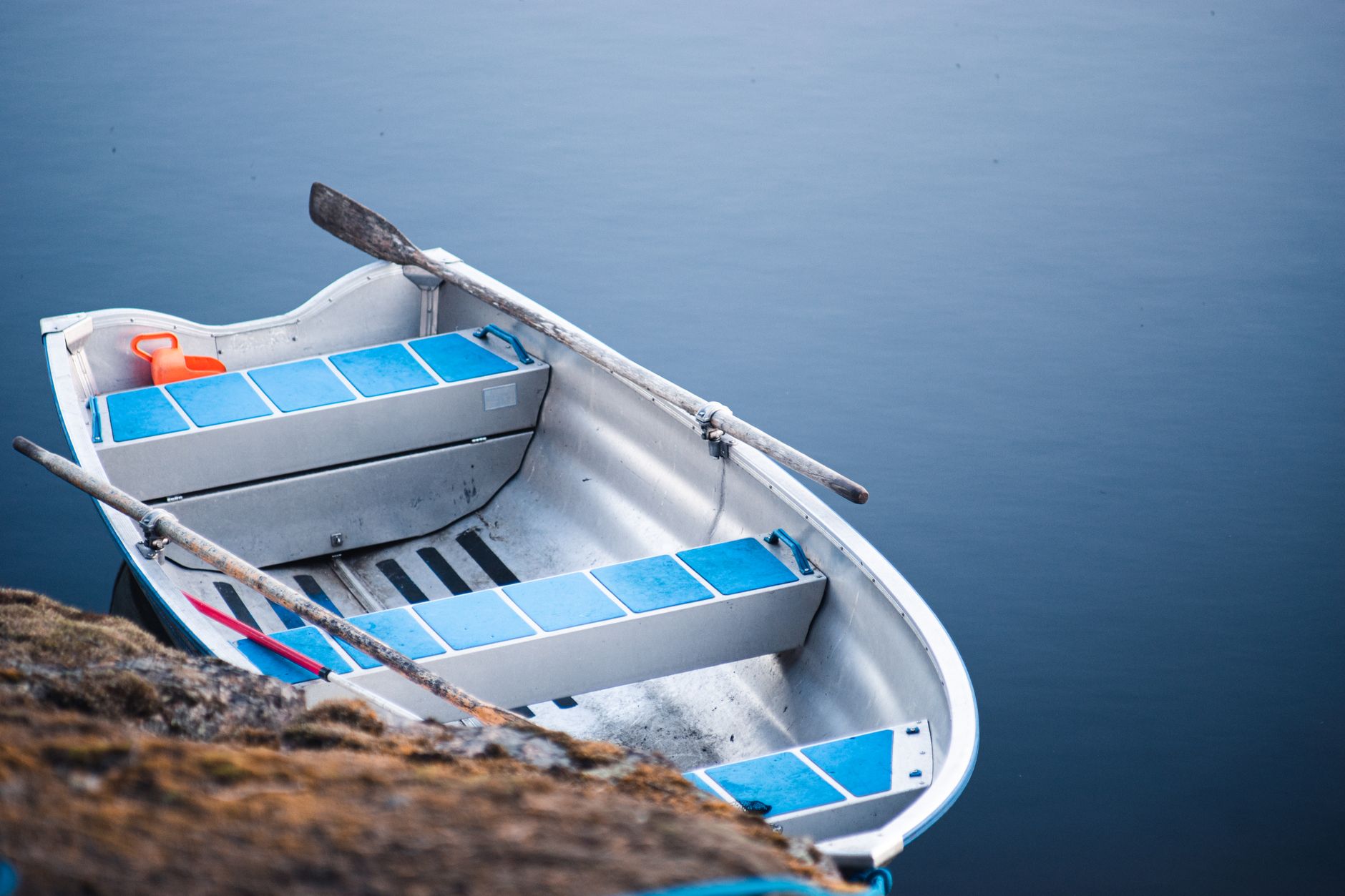 Colorful rowing blades leaning against a boathouse wall showing geometric stripe patterns