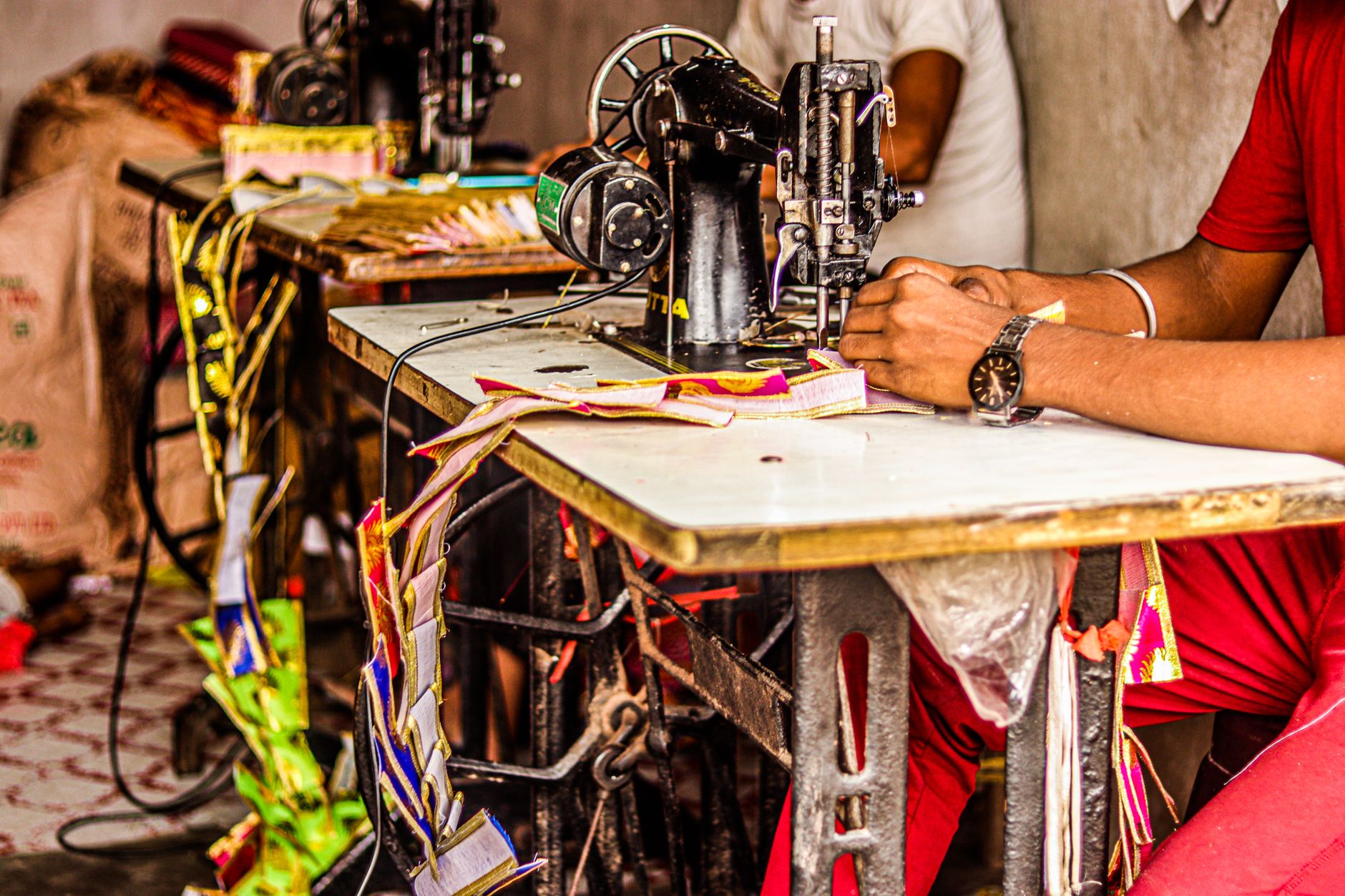 A tailor working on a structured shirt collar in a professional workshop setting