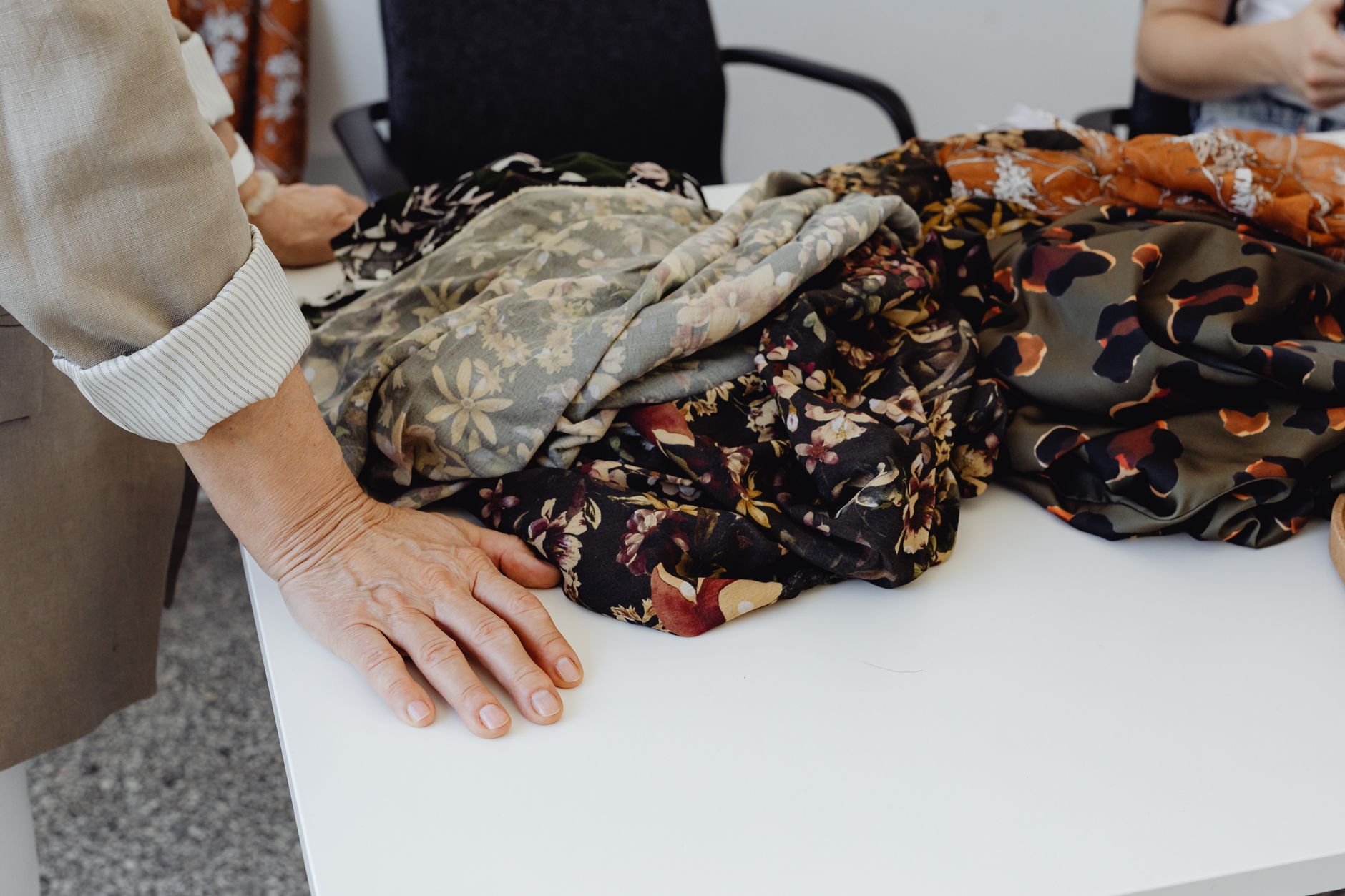 Tailor examining jacket construction in a workshop setting