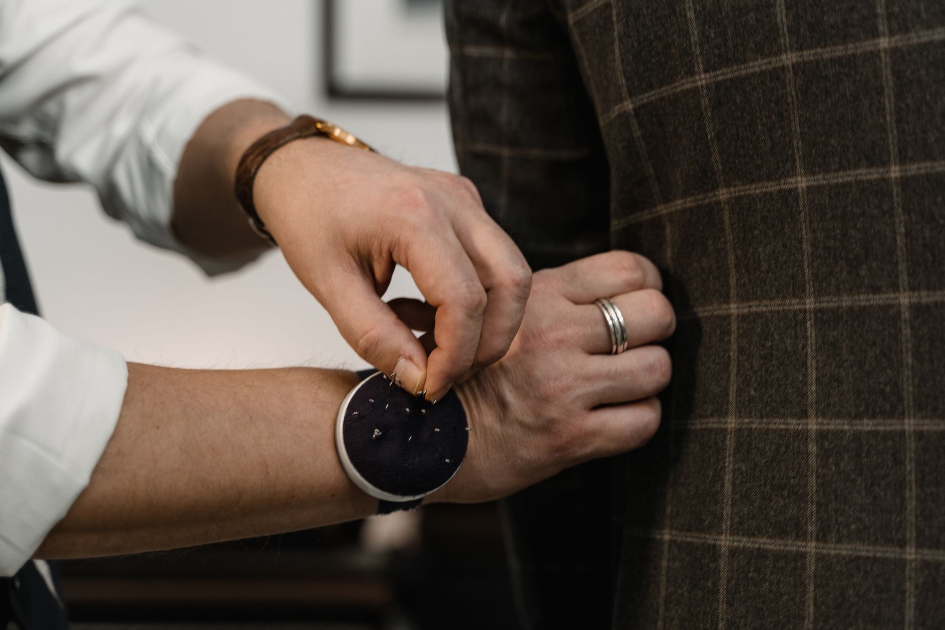 Tailor working on formal trouser construction in a professional studio