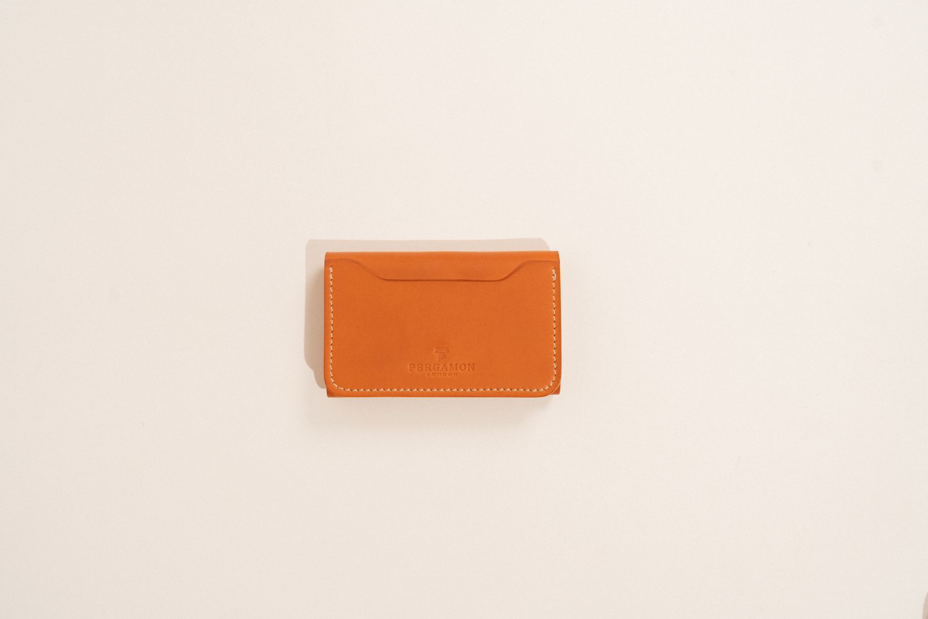 Simple vegetable-tanned leather band with antique brass buckle laid flat on a neutral surface