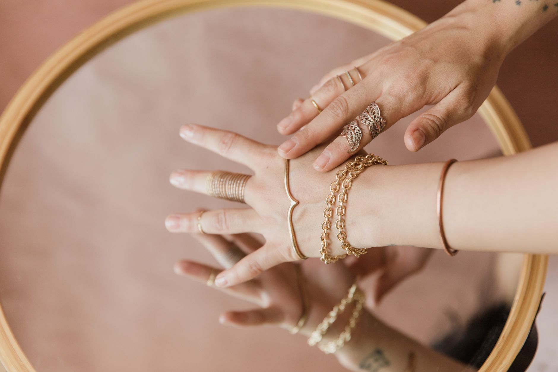 Minimalist gold bangle bracelet resting on a neutral surface