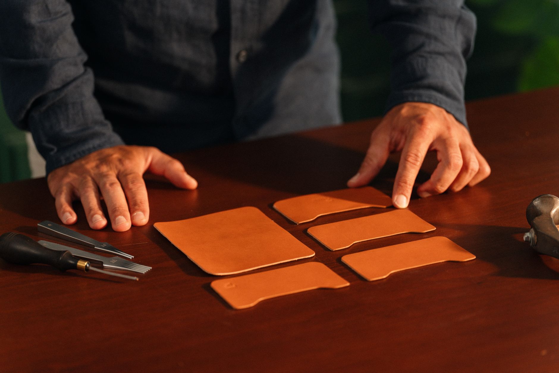 Artisan leather goods workshop with tools and material samples on a workbench