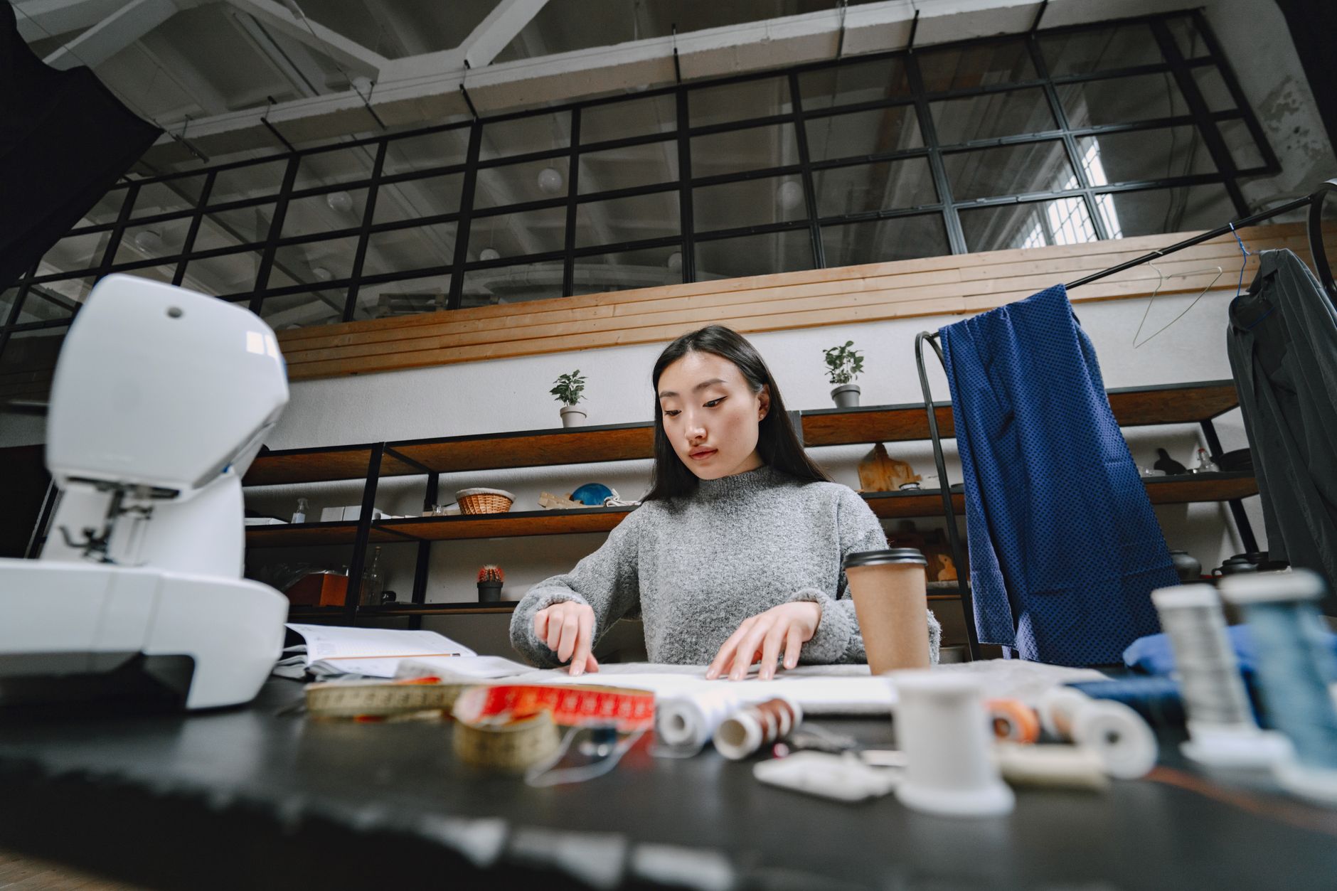 A tailor working on structured garment construction in a design studio