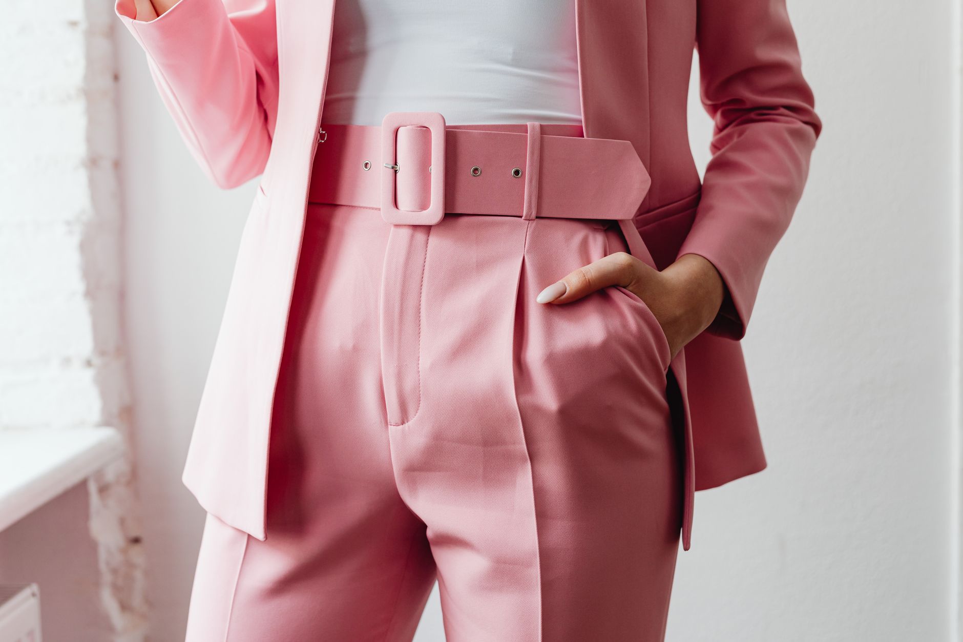 Wide leather cinch belt with staggered buckle closures styled over tailored trousers