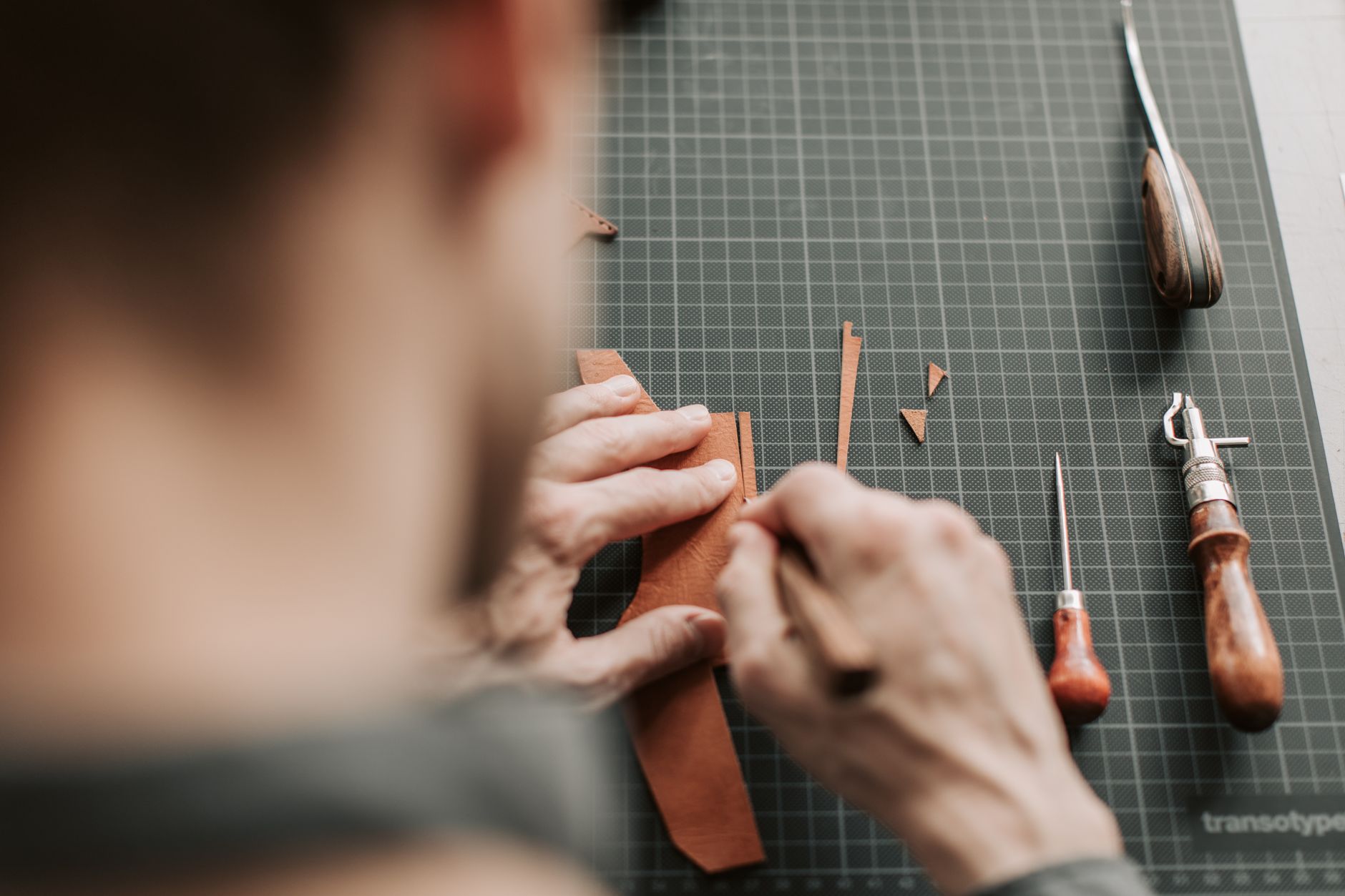 A leatherworker constructing a leather bag using traditional saddlery techniques