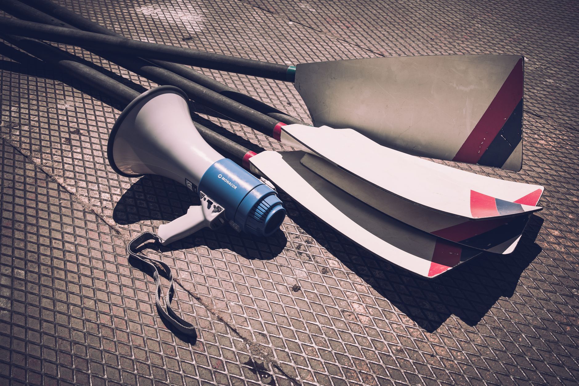 Close-up of a rowing shell outrigger arm with metal fittings and rigging hardware