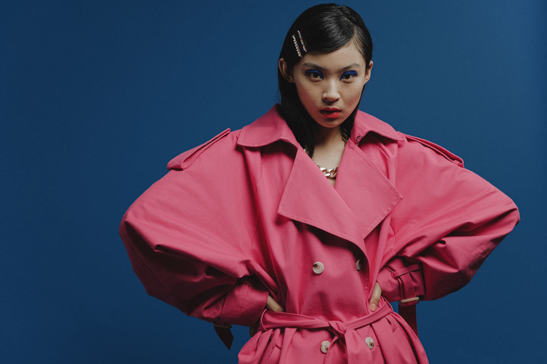 Model wearing sculptural avant-garde fashion with rigid chest panel and minimal skirt volume