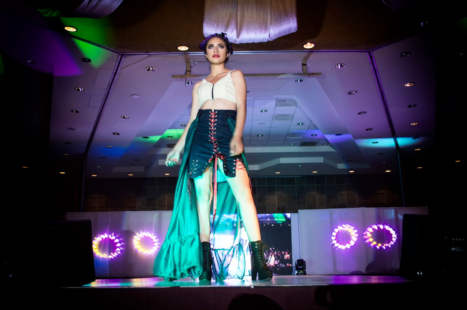 Runway model in architectural skirt silhouette with wide structured waistband detail