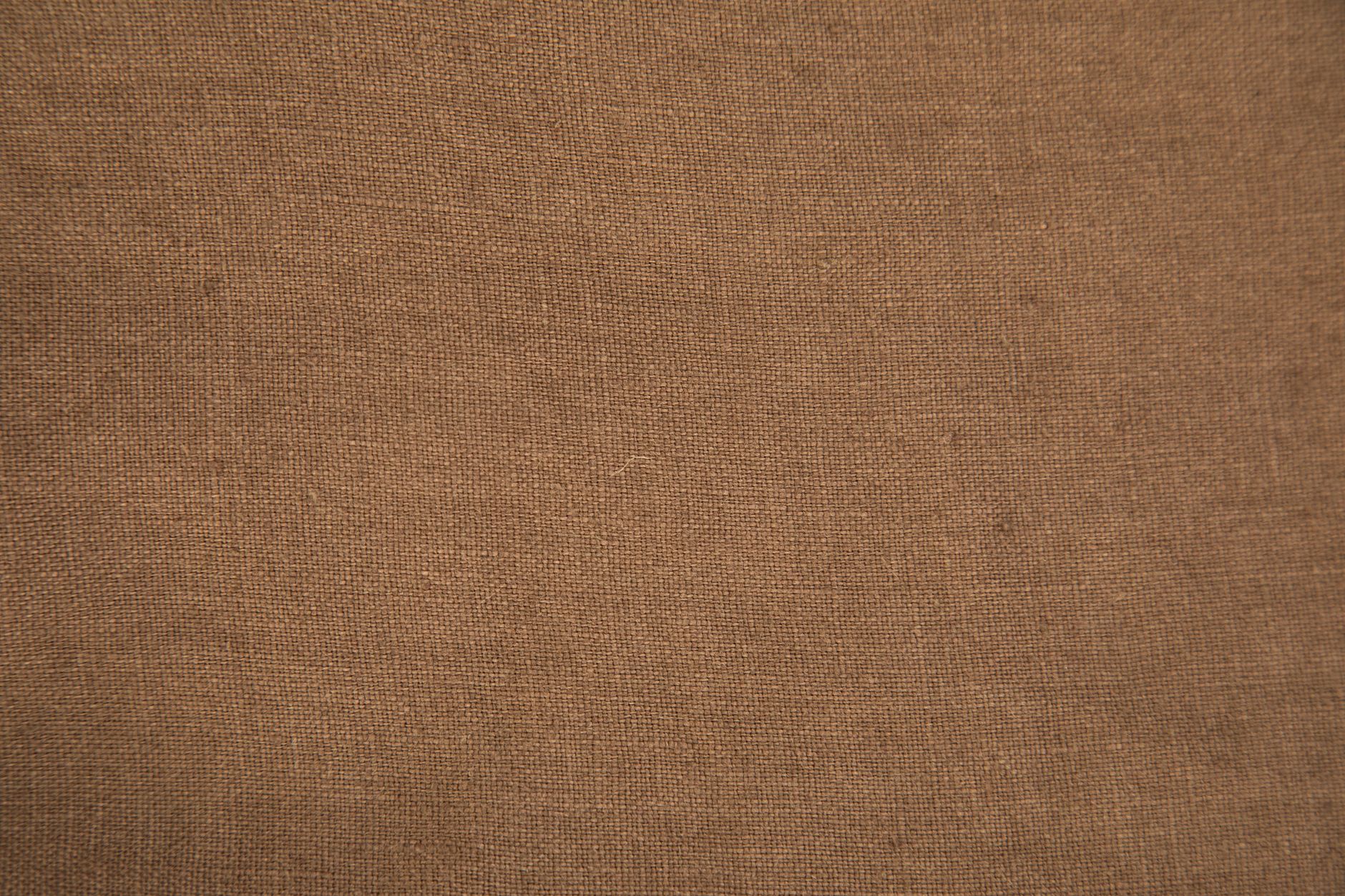 Detail shot of a lapel pin worn on a structured linen blazer in a neutral off-white tone