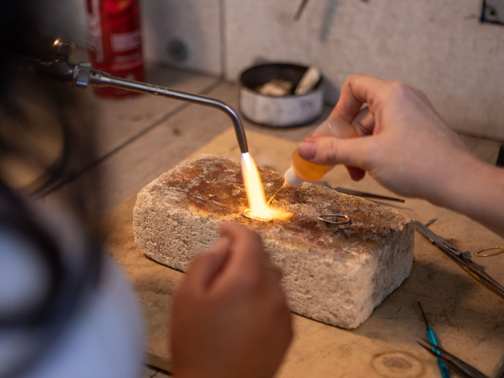 Fine jewelry pieces laid out on a workbench in a designer studio