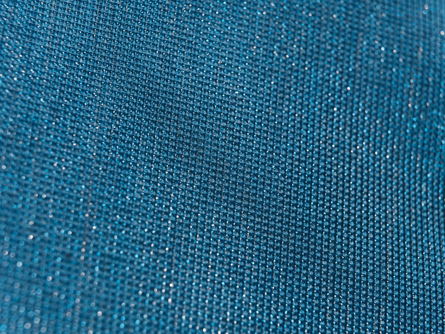 Close-up of a shimmering metallic woven fabric with a tight, structured weave pattern